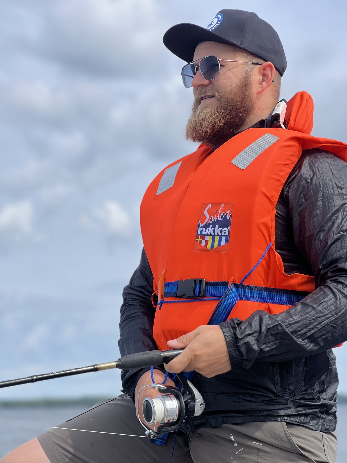Joonas kalastaa veneessä pelastusliivit päällä